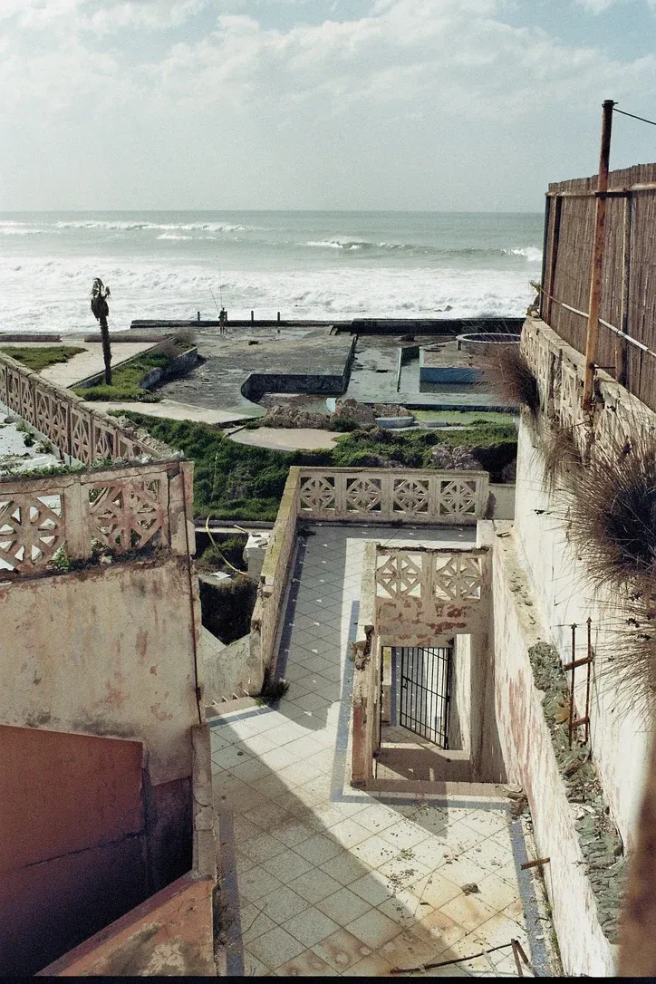 Solitary figure fishing from a concrete block along the Atlantic coastline near Rabat