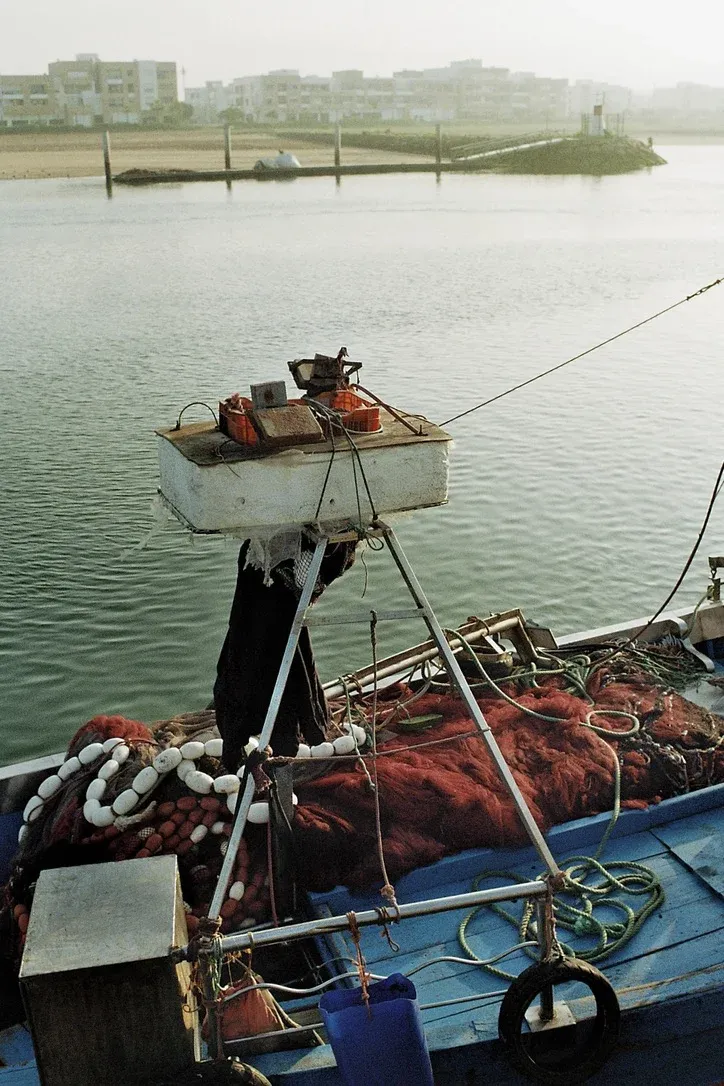 A fishing boat with colorful red nets at Rabat Harbour