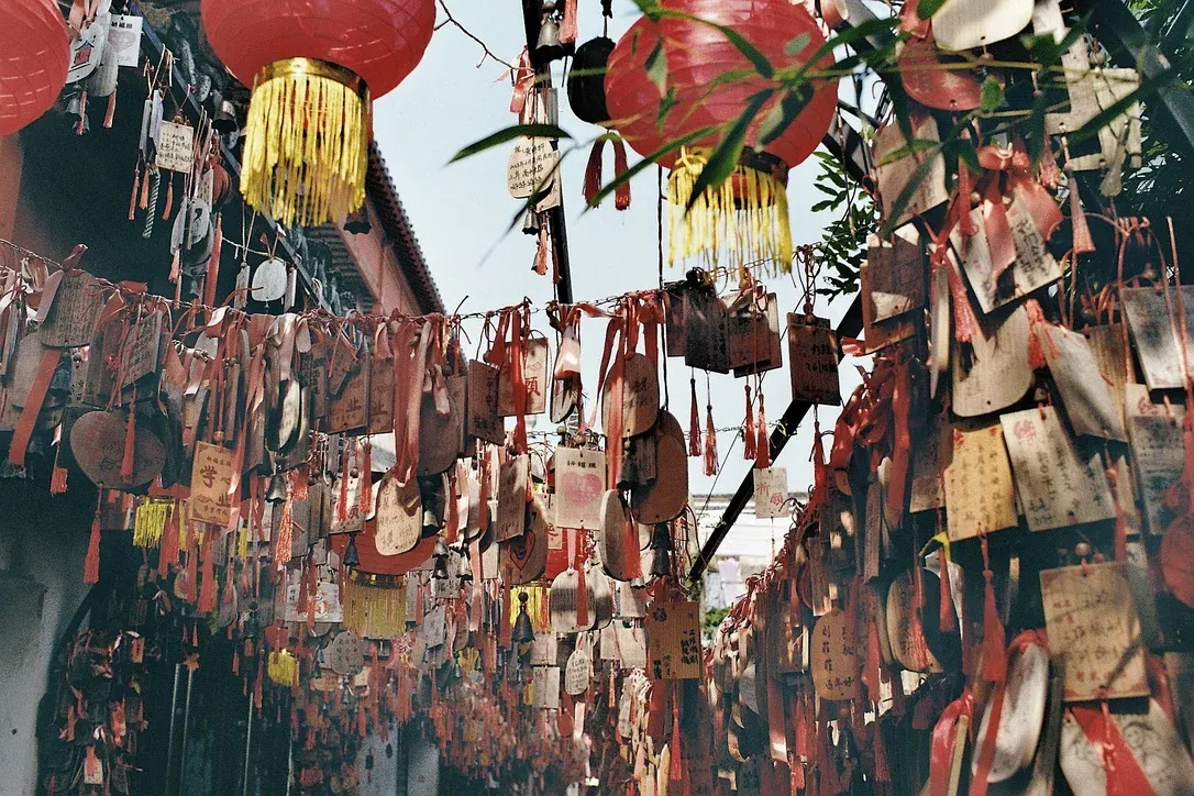 Wooden plaques with written wishes and spells hanging in a Suzhou alleyway